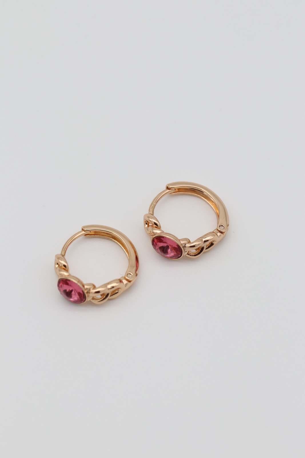 Gold-plated hoop earrings with intricate chain details and bold pink gemstone centers, displayed on a neutral background.