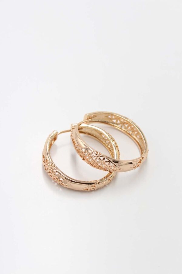 Gold hoop earrings with intricate engraved floral patterns on a smooth background.