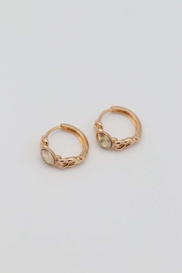 Gold-plated hoop earrings with intricate chain details and bold yellow gemstone centers, displayed on a neutral background.