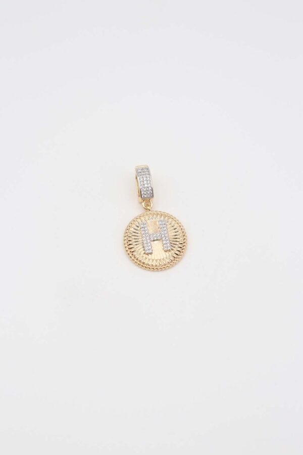 Gold pendant featuring a crystal-encrusted letter 'H' in a circular frame