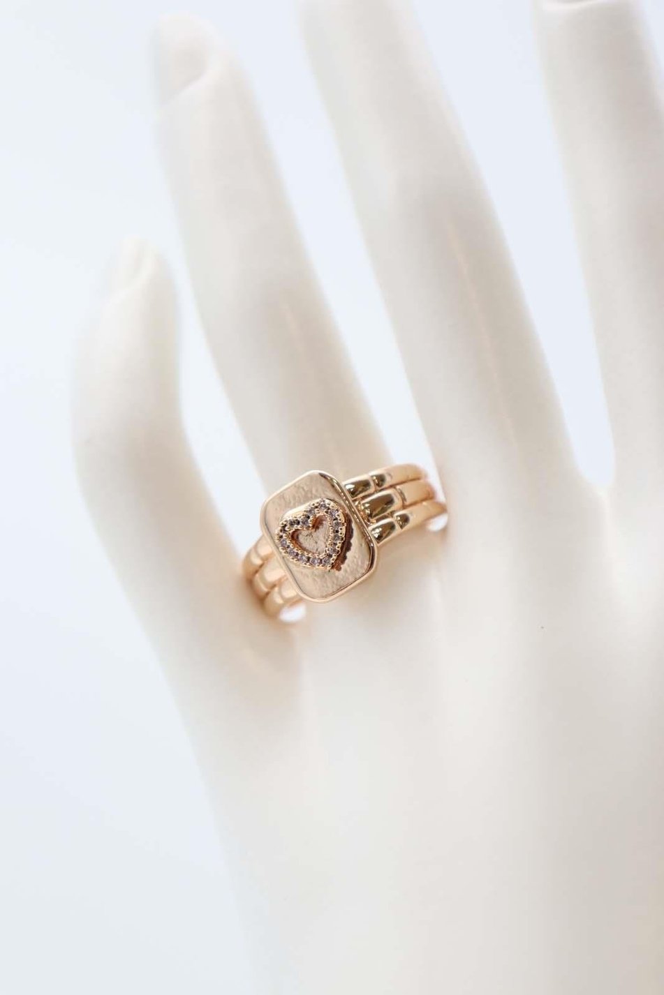 Gold ring with heart emblem and crystal details